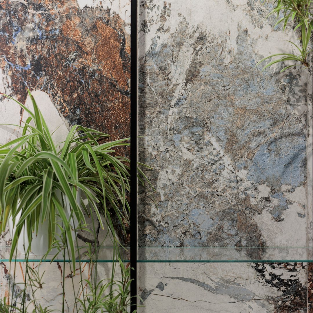 parete con pianta rivestita con gres effetto marmo variegato bianco grigio rosso, blu e azzurro